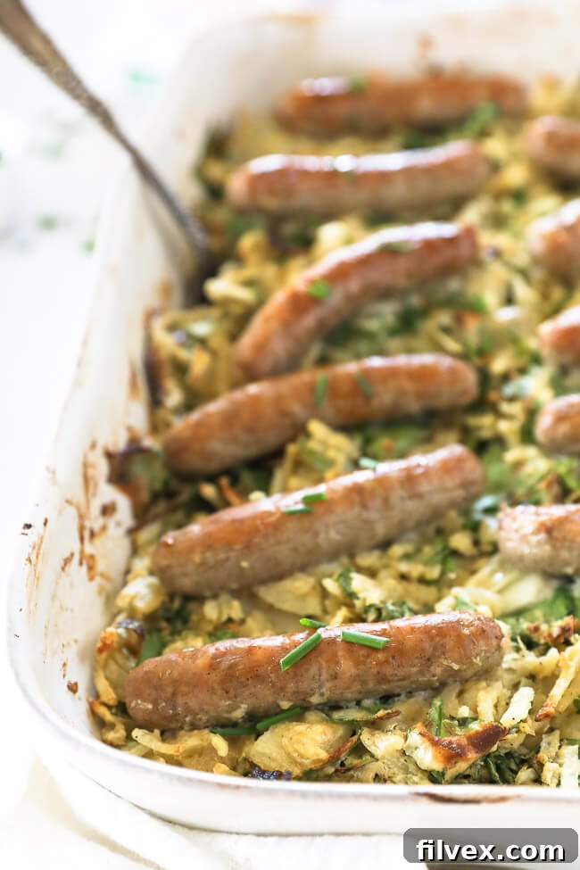 Vertical angled close up image of sausages topping a breakfast hashbrown casserole. 