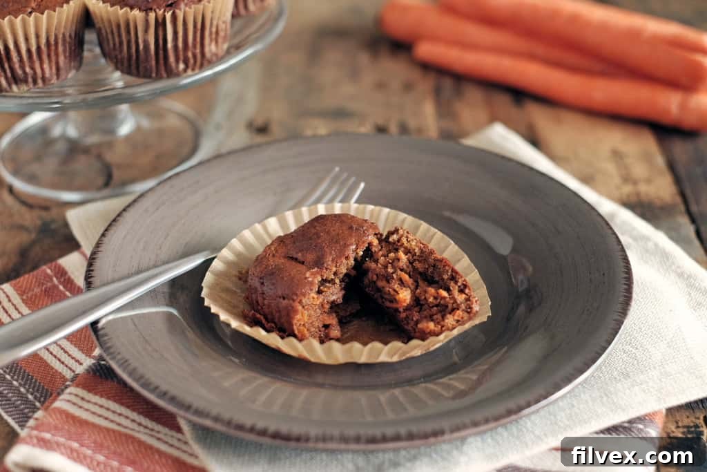 Two perfectly baked and golden-brown Paleo Carrot Cake Muffins, showcasing their rich texture and healthy ingredients.