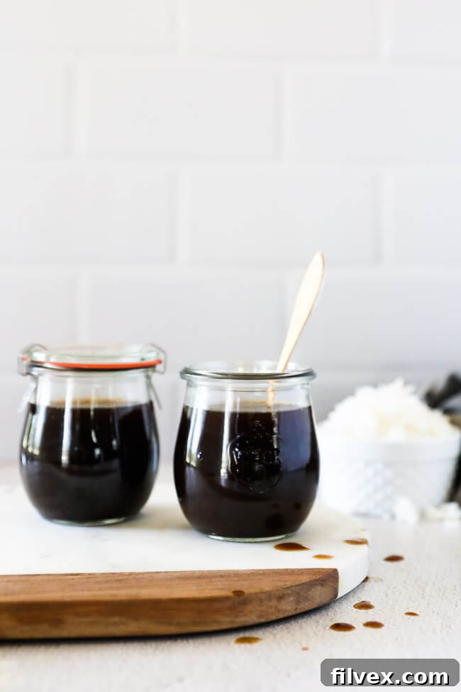 Homemade coconut aminos in two jars on a countertop with rice in background