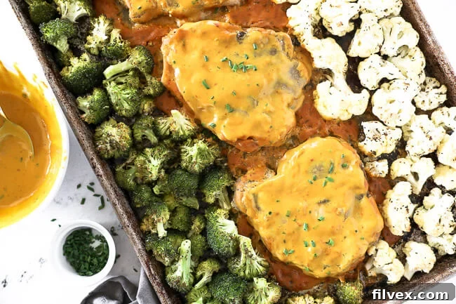 Honey mustard pork chops on a sheet pan with broccoli and cauliflower. 