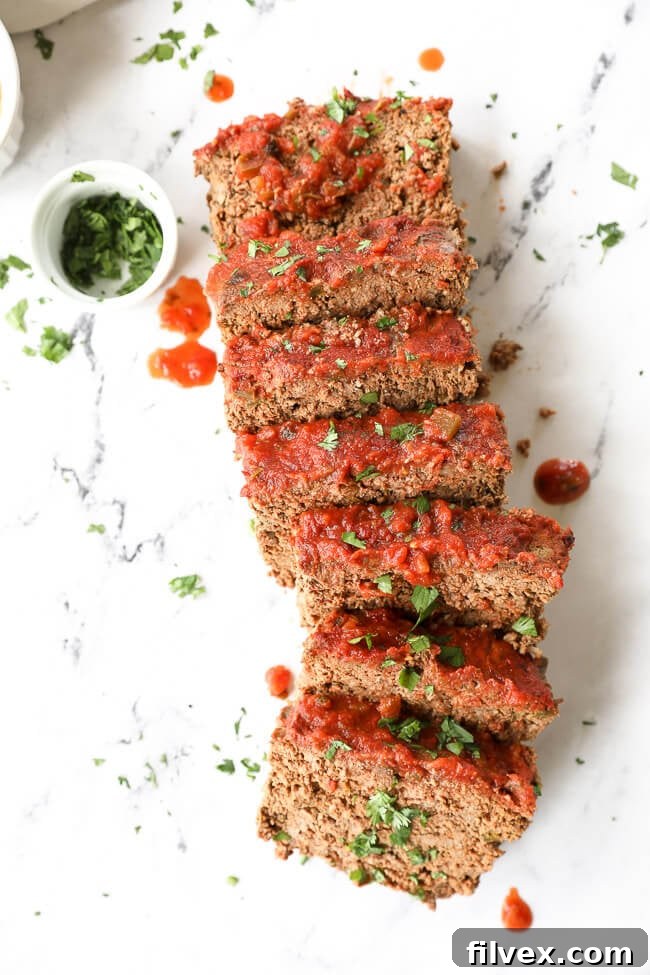 Mexican taco meatloaf sliced and laid out with cilantro and salsa topping. A delicious and easy ground beef recipe.