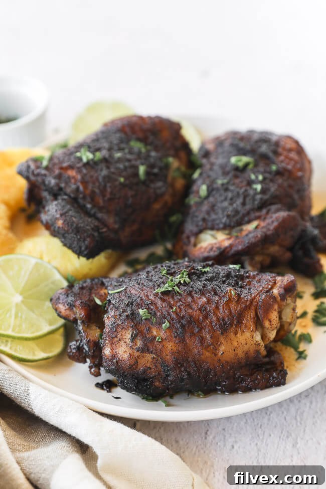 Easy slow cooker jerk chicken served on a plate with fresh pineapple slices and a lime wedge, presented at a vertical angle.