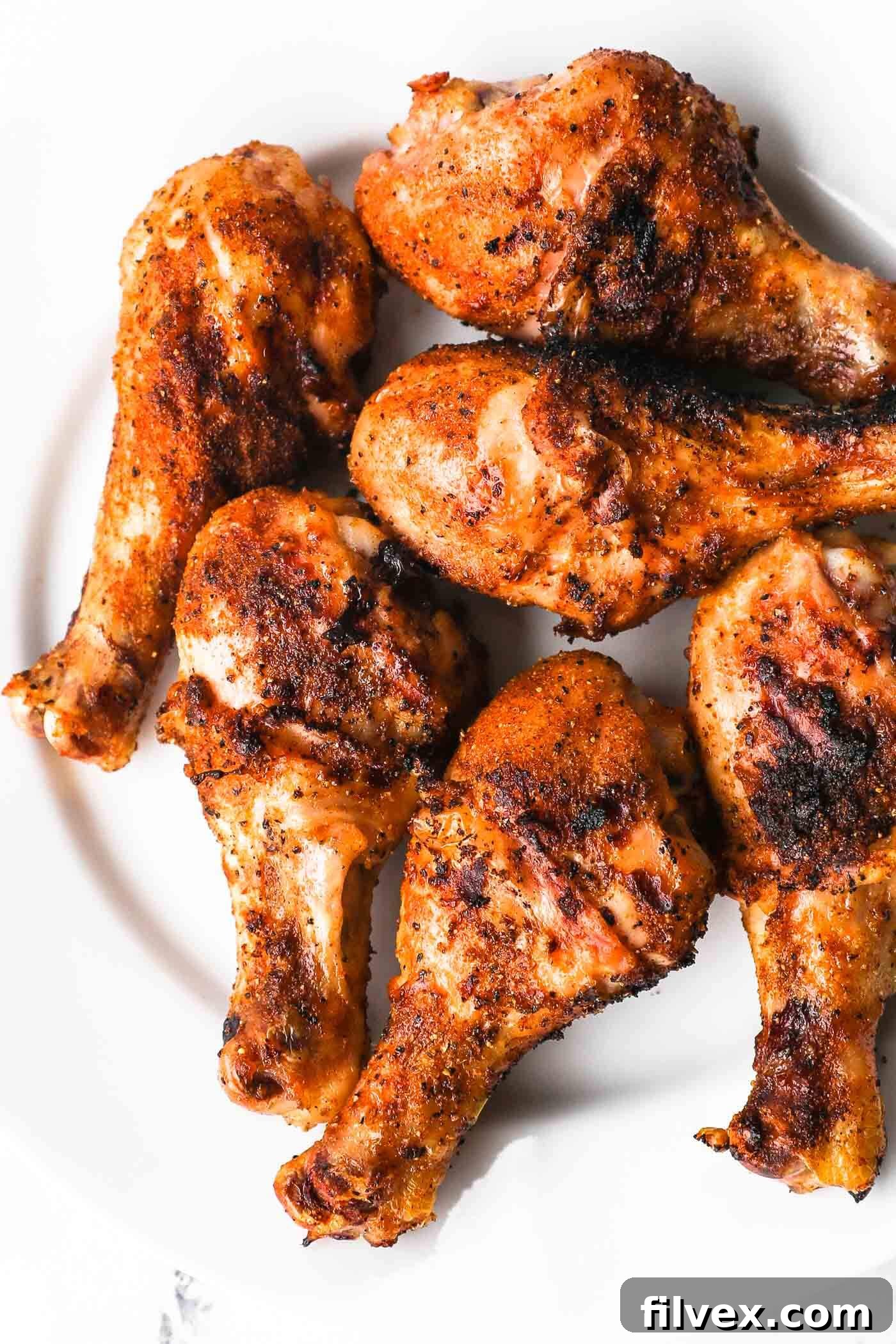 Perfectly grilled chicken drumsticks with crispy skin and grill marks, ready to be served.
