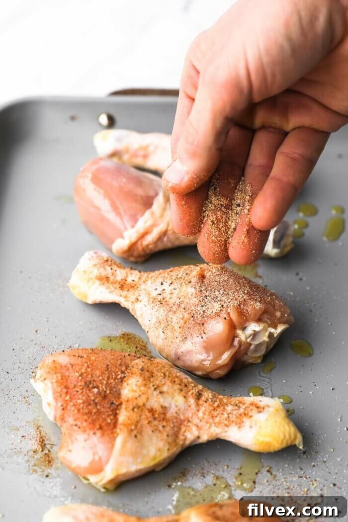 Chicken drumsticks being seasoned with the spice mix.