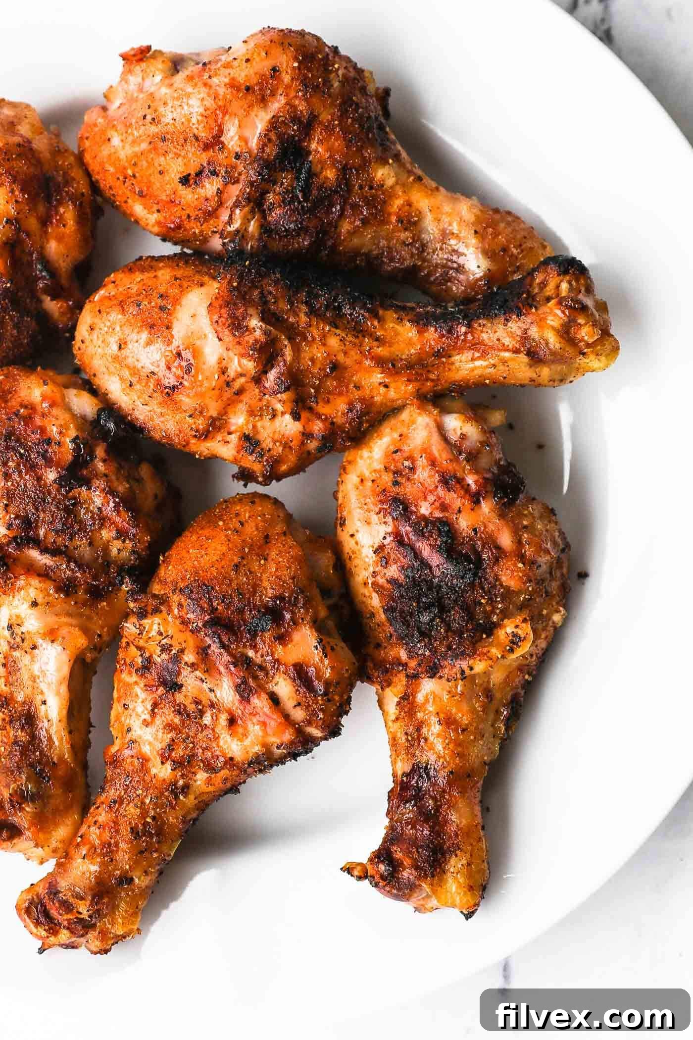 Plated grilled chicken drumsticks, garnished and ready to serve.