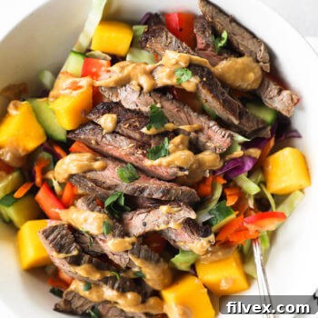 thai beef salad served in a bowl with cashew sauce drizzled on top.