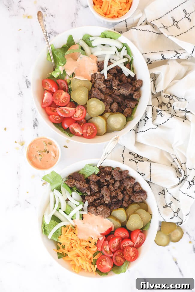 Overhead image of two salad bowls with ingredients separate out in the bowls and sauce on the side.