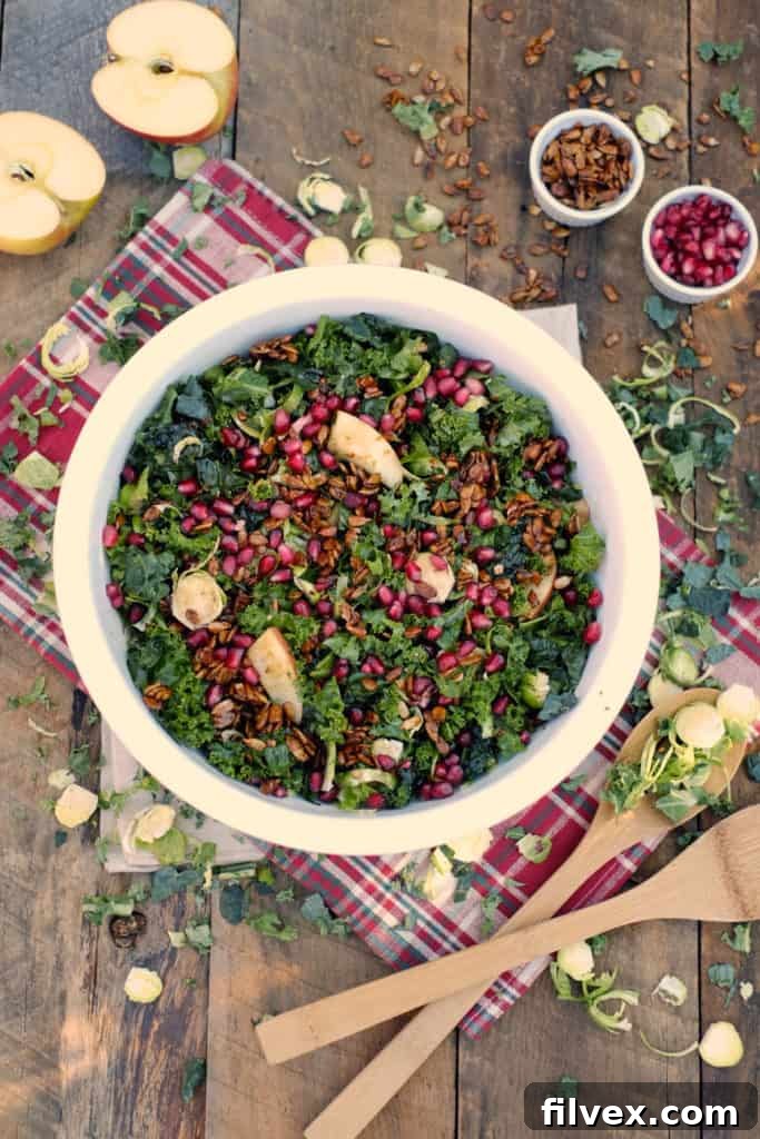 A vibrant and fresh winter salad with kale, Brussels sprouts, and pomegranate seeds.