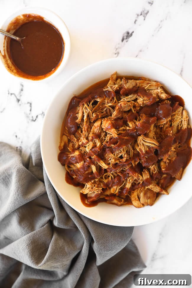 Overhead image of chicken in a bowl with bbq sauce on the side