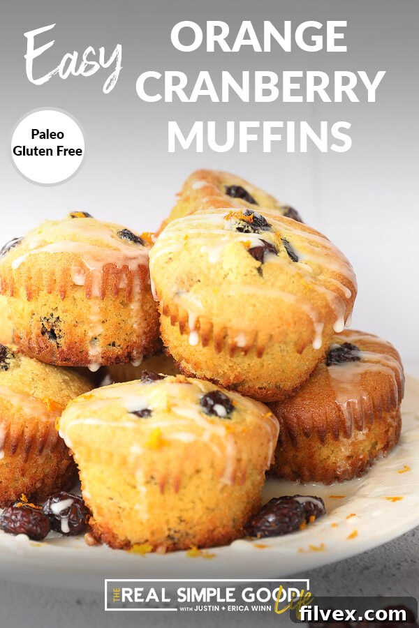 Vertical angled photograph of gluten-free orange cranberry muffins stacked on a rustic plate, with a soft focus background.