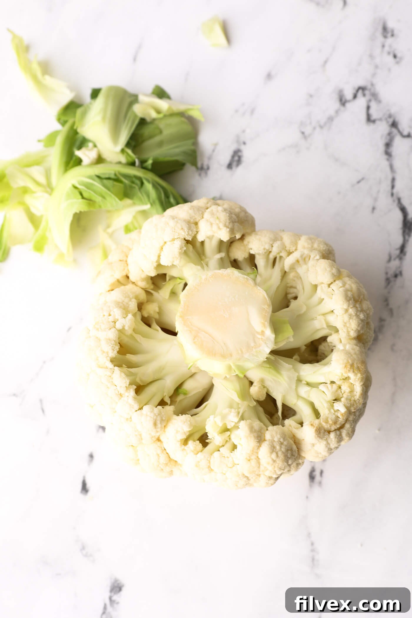 Cauliflower with leaves removed, showing clear access to the florets and stalk.