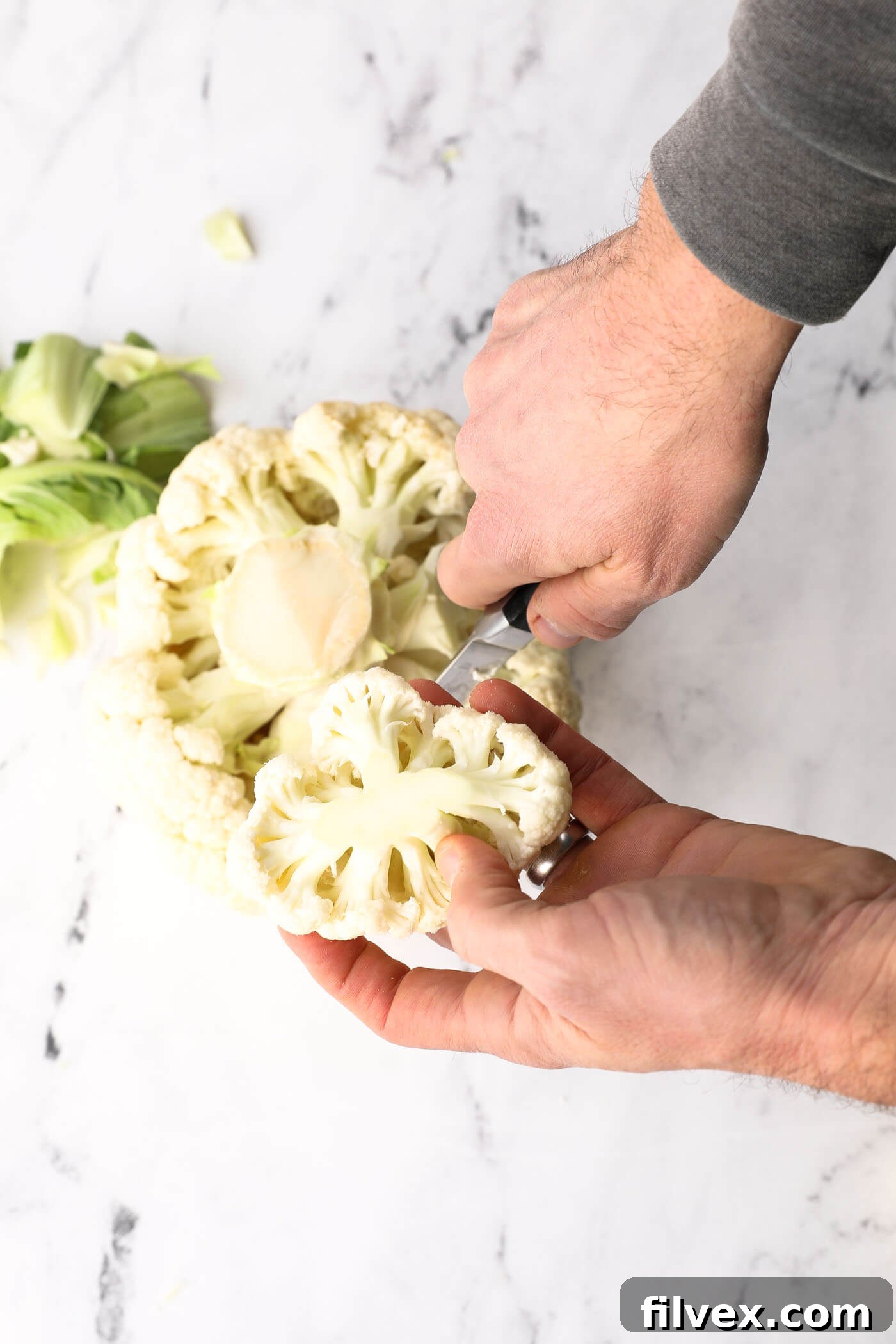 Large chunks of cauliflower florets after initial cutting, indicating further preparation is needed.