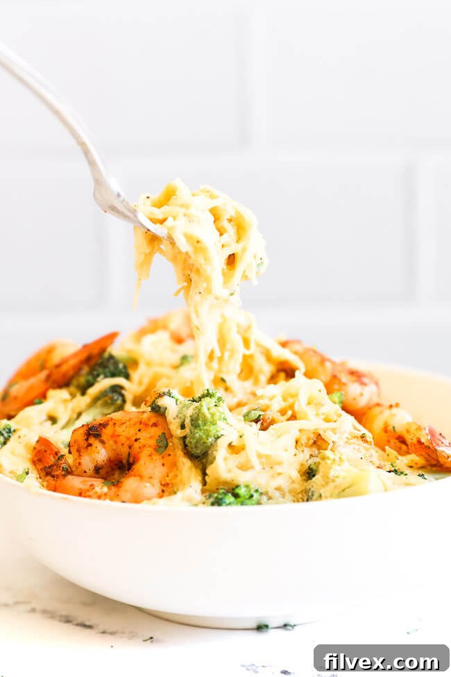 Image of scooping a forkful of spaghetti squash alfredo out of a bowl. 