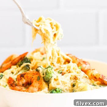 Spaghetti squash shrimp alfredo in a bowl with fork pulling noodles out