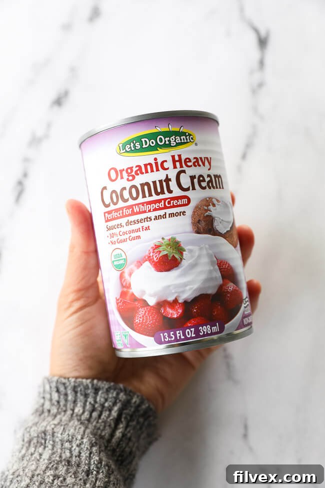 Holding a can of our preferred coconut cream for making coconut whipped cream - Let's Do Organic Organic Heavy Coconut Cream. 