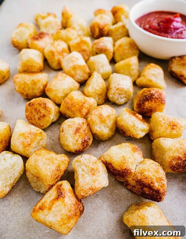 Cauliflower gnocchi nuggets on parchment paper with ketchup