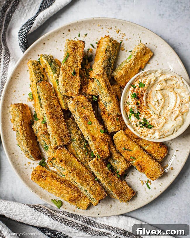 Zucchini fries on a plate with sauce in a ramekin