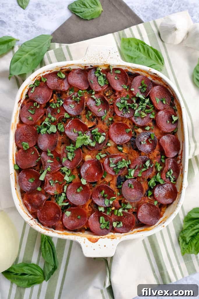 A vibrant close-up of Paleo Lasagna, freshly baked in a casserole dish, bubbling with rich tomato sauce, savory sausage, and pepperoni, with delicate spaghetti squash strands visible. This gluten-free, dairy-free, and Whole30 compliant casserole is a perfect healthy comfort food.