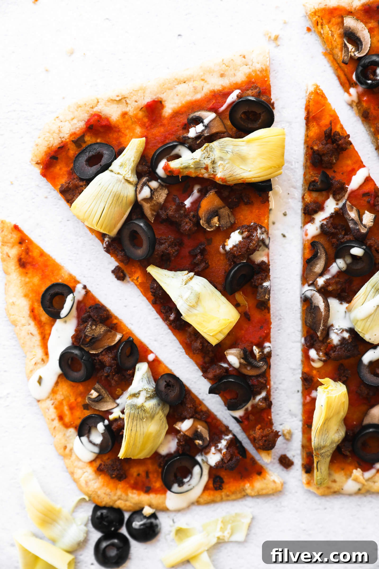 A close-up view of a perfectly baked piece of homemade gluten-free flatbread pizza, highlighting its crispy crust and vibrant toppings.