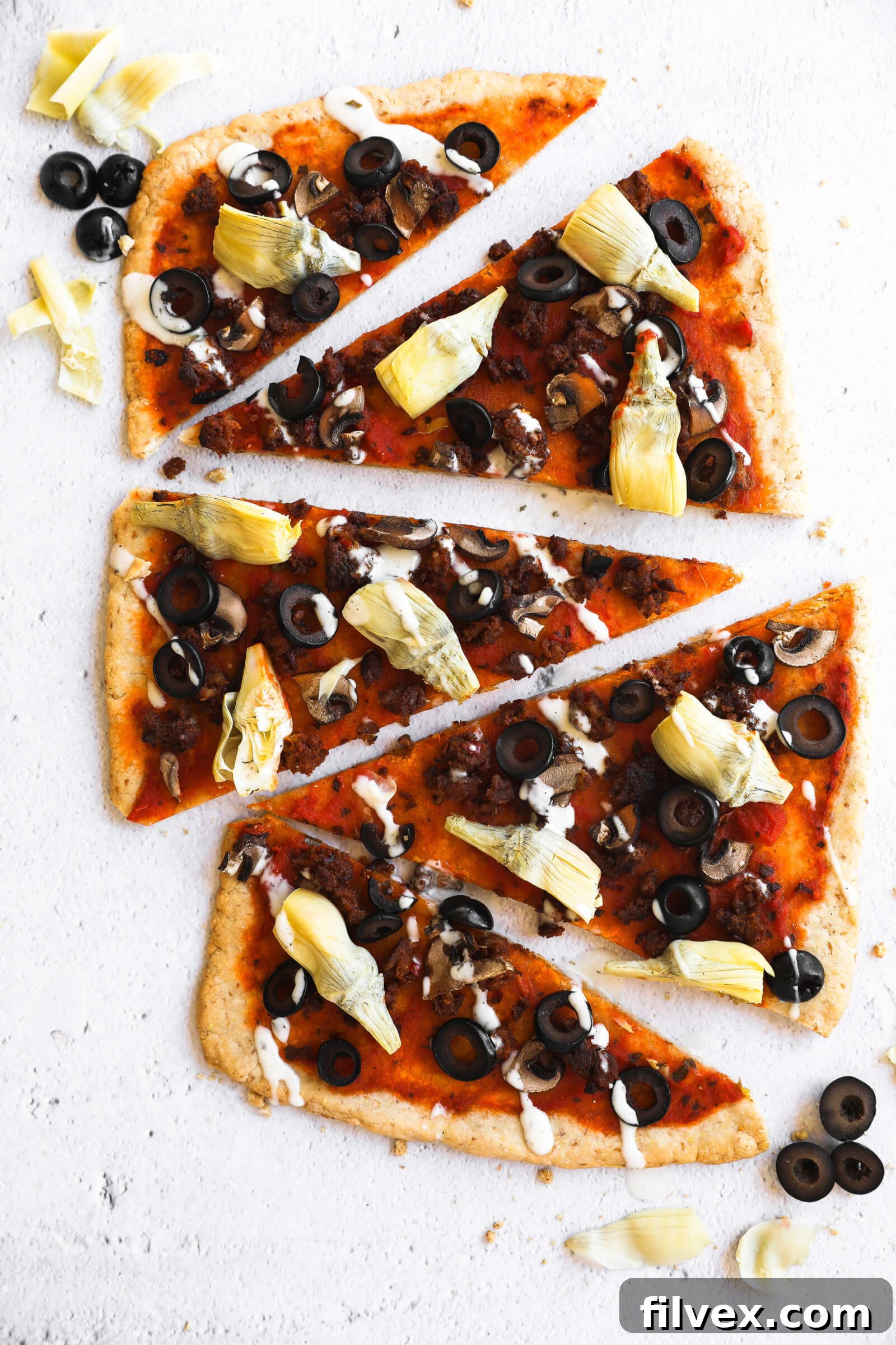 A vibrant display of various flatbread pizza slices scattered across a surface, showcasing different topping combinations.