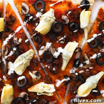 Gluten free flatbread pizza sliced into pieces with ranch drizzled on top, ready to eat.