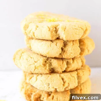 Stack of five gluten free shortbread cookies with lemon zest sprinkled on top.