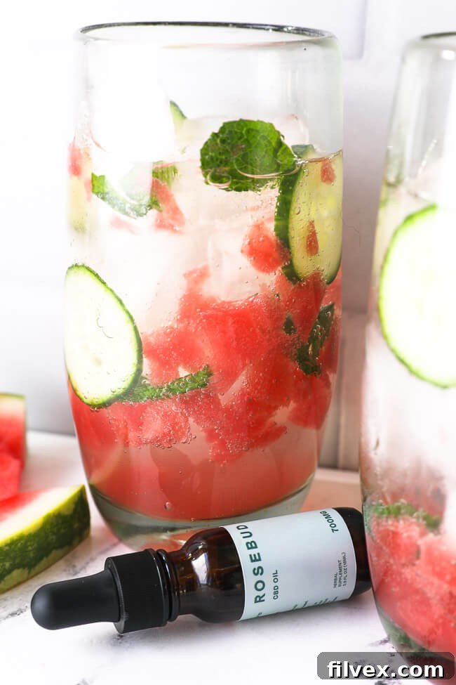 Watermelon mojito mocktail with cbd bottle in the foreground. 