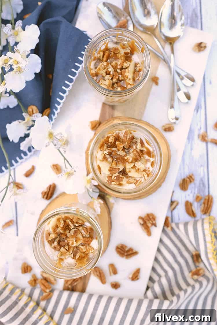 Layered Banana Cream Dessert: A close-up view of the delicious, creamy, and layered dessert in a glass jar, topped with pecans and salted caramel.