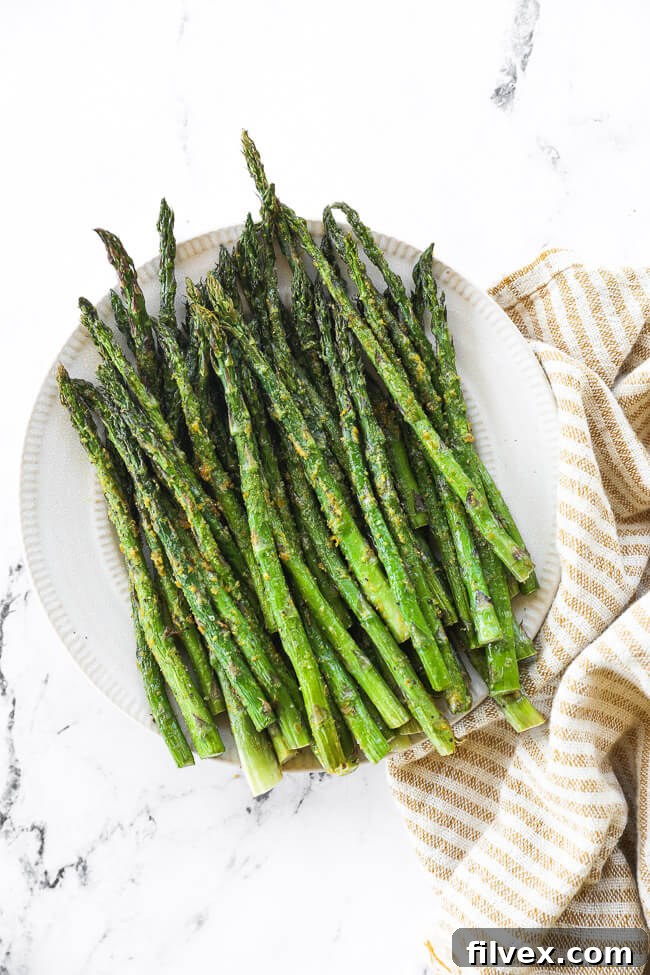 Air fryer asparagus served on a plate as part of a meal.