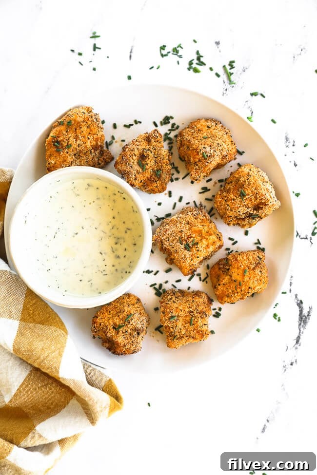 A simple yet satisfying plate featuring perfectly cooked air fryer chicken nuggets alongside a small bowl of creamy ranch dipping sauce.