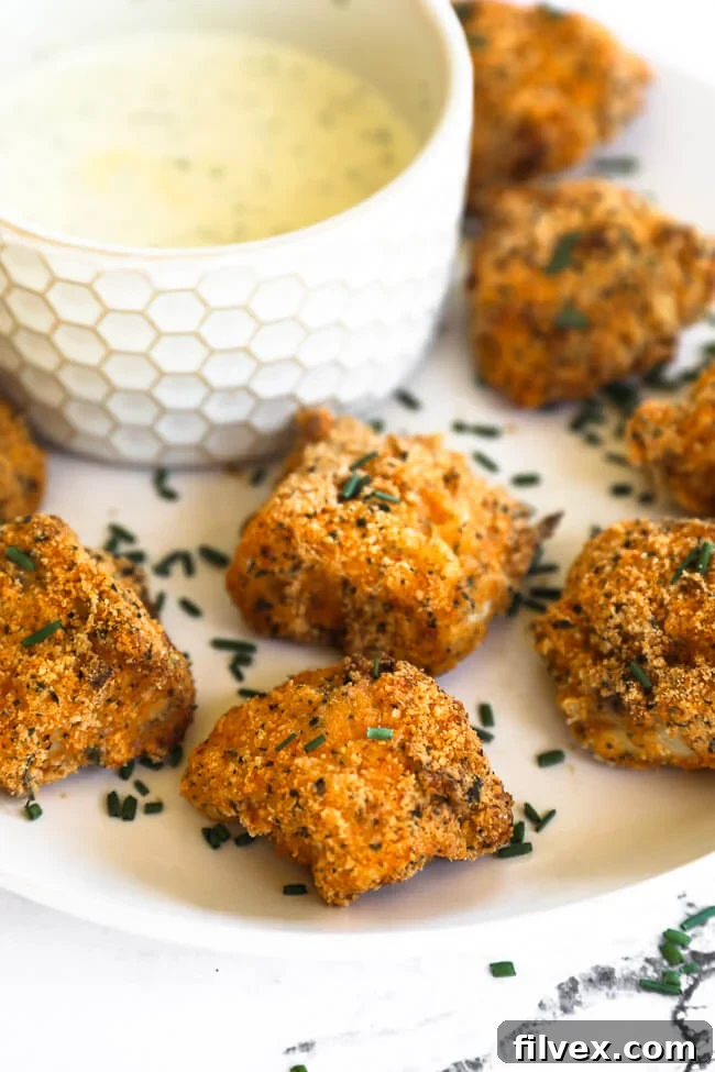 An enticing close-up, angled shot of air fryer chicken nuggets on a plate, highlighting their beautiful golden-brown and crispy coating.
