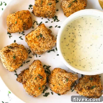 Gluten free air fryer chicken nuggets on a plate with ranch dipping sauce.
