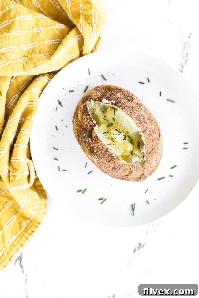 Two air fryer baked potatoes in a basket