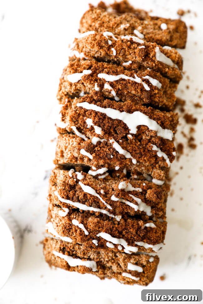 Overhead image of a loaf of gluten free and dairy free pumpkin bread with coconut butter drizzled on top.