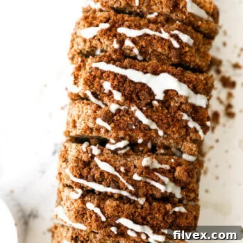 Overhead image of a loaf of gluten free and dairy free pumpkin bread with coconut butter drizzled on top.