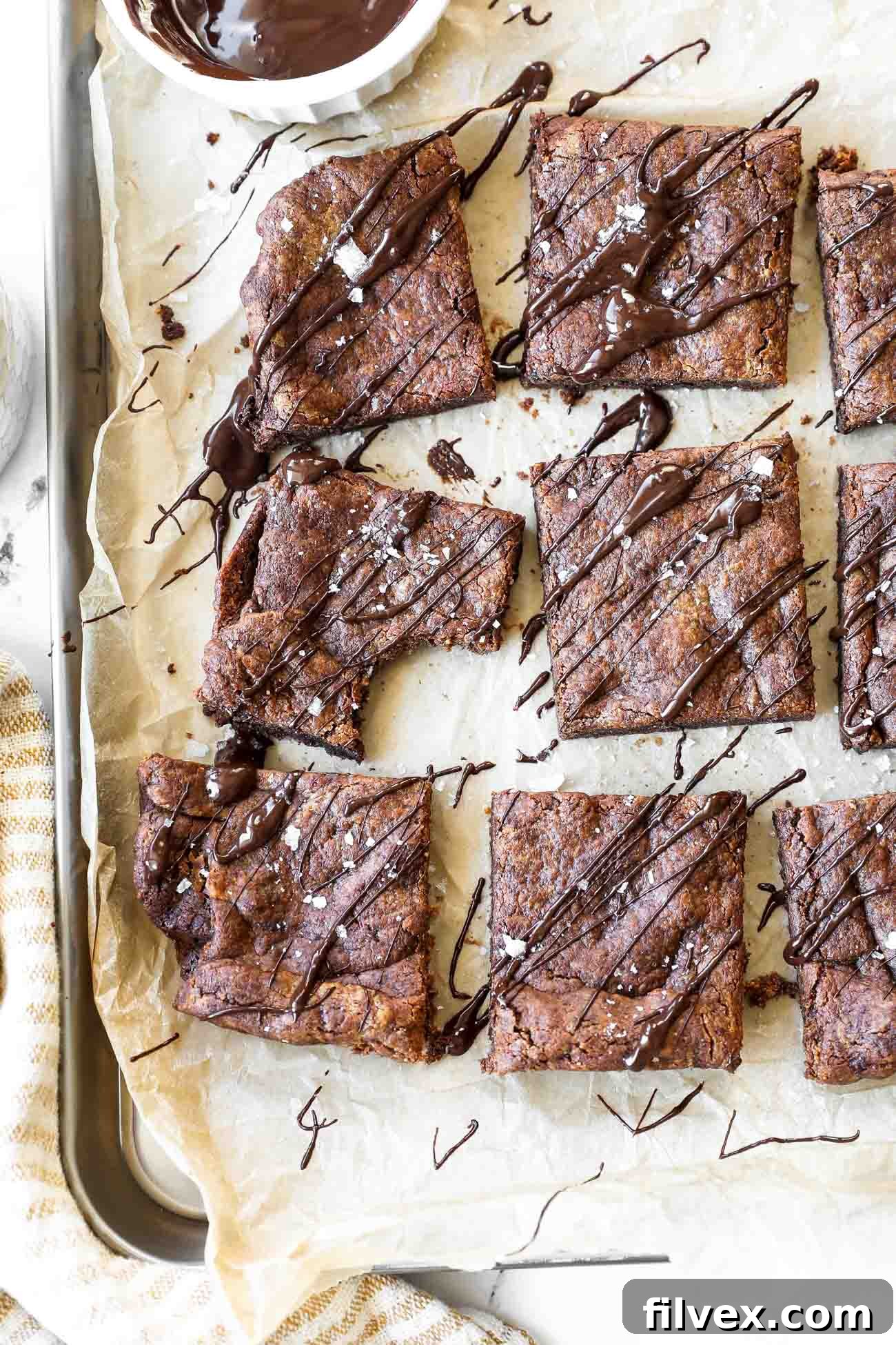 Close-up vertical image of perfectly baked dairy-free, flourless brownies on a cooling rack, showing their rich brown color.