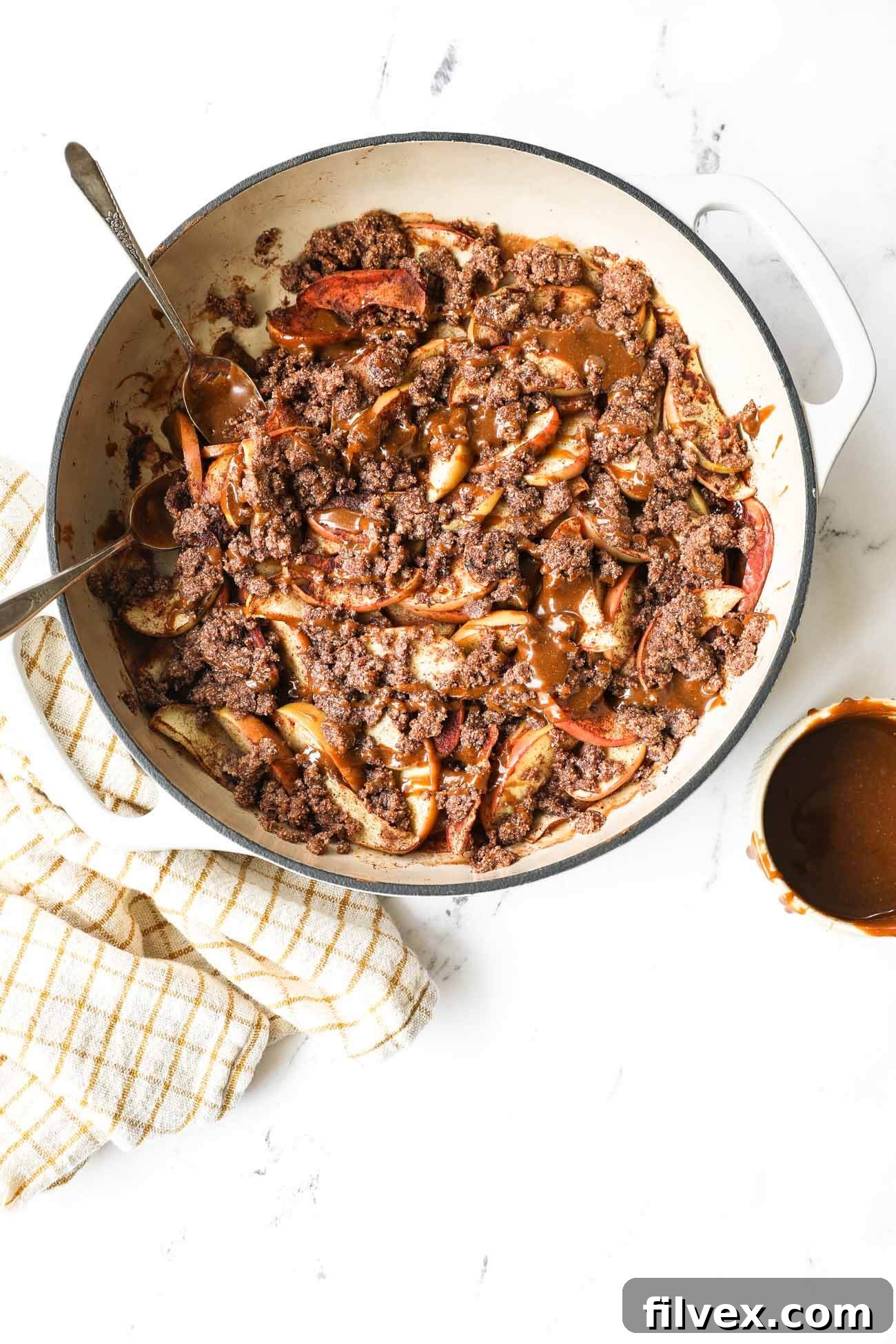 Freshly sliced apples ready for the crumble, showcasing a mix of tart Granny Smith and sweet Honeycrisp varieties. Each slice is uniform, promising even baking.