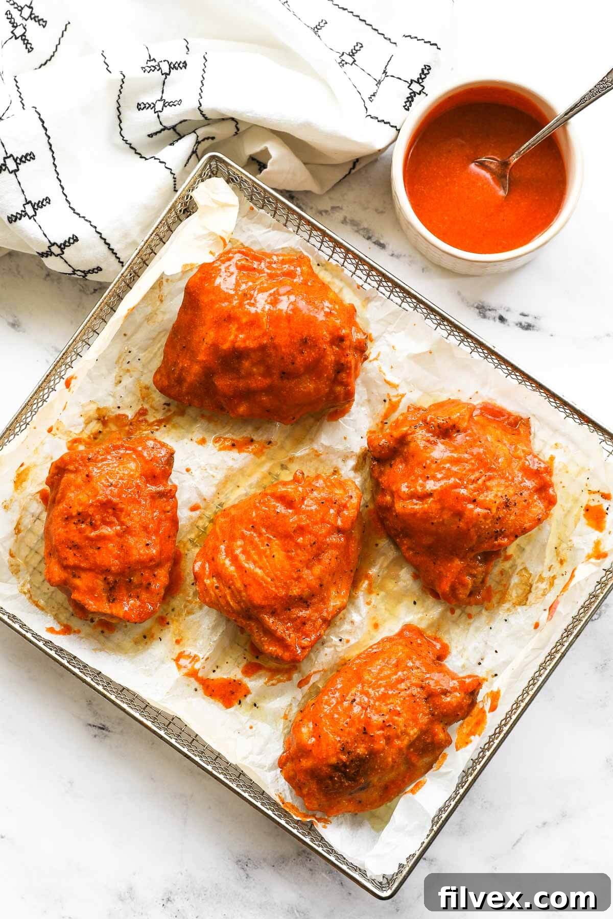 Crispy buffalo chicken thighs cooked in the oven or air fryer