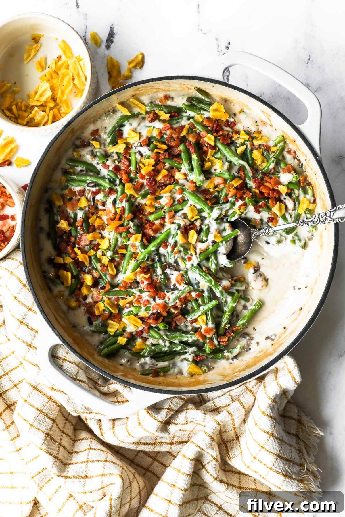 Crumbled bacon bits and plantain chips as a topping on a green bean casserole.
