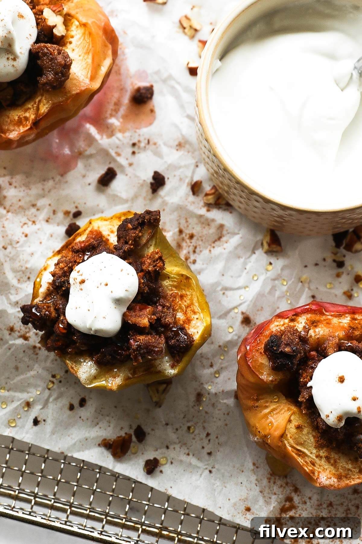 Overhead image of air fryer apples with crumble topping and whipped coconut cream with extra whipped cream on the side.