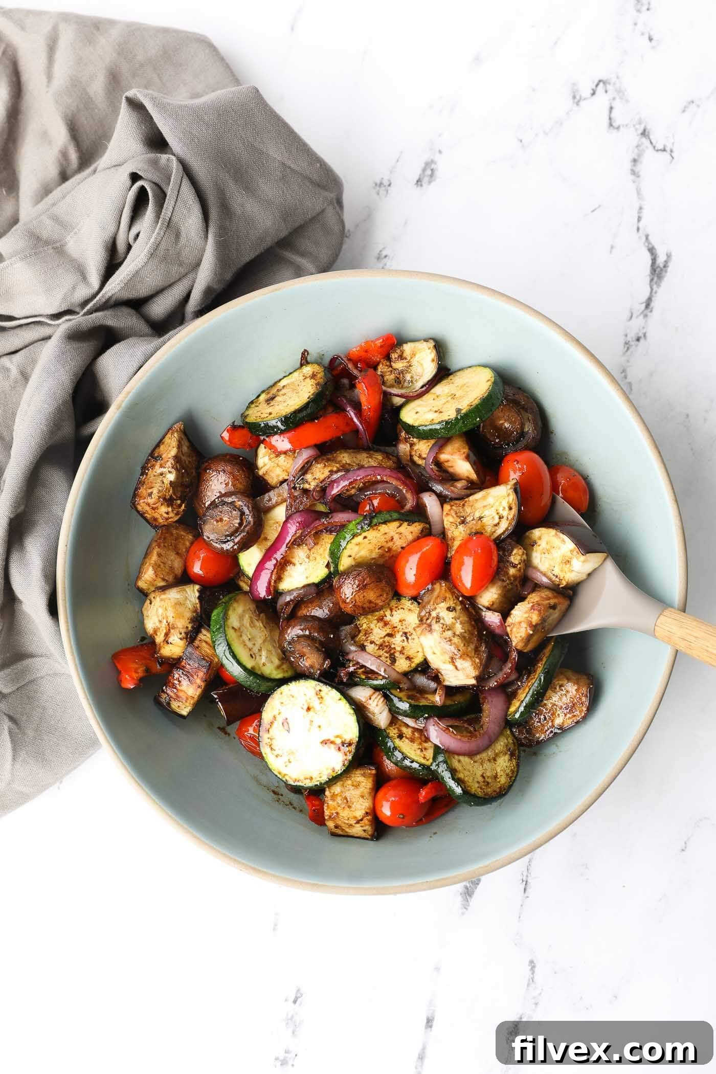 A vibrant bowl of freshly grilled zucchini, bell peppers, red onion, and cherry tomatoes, perfectly tossed in a homemade balsamic marinade.