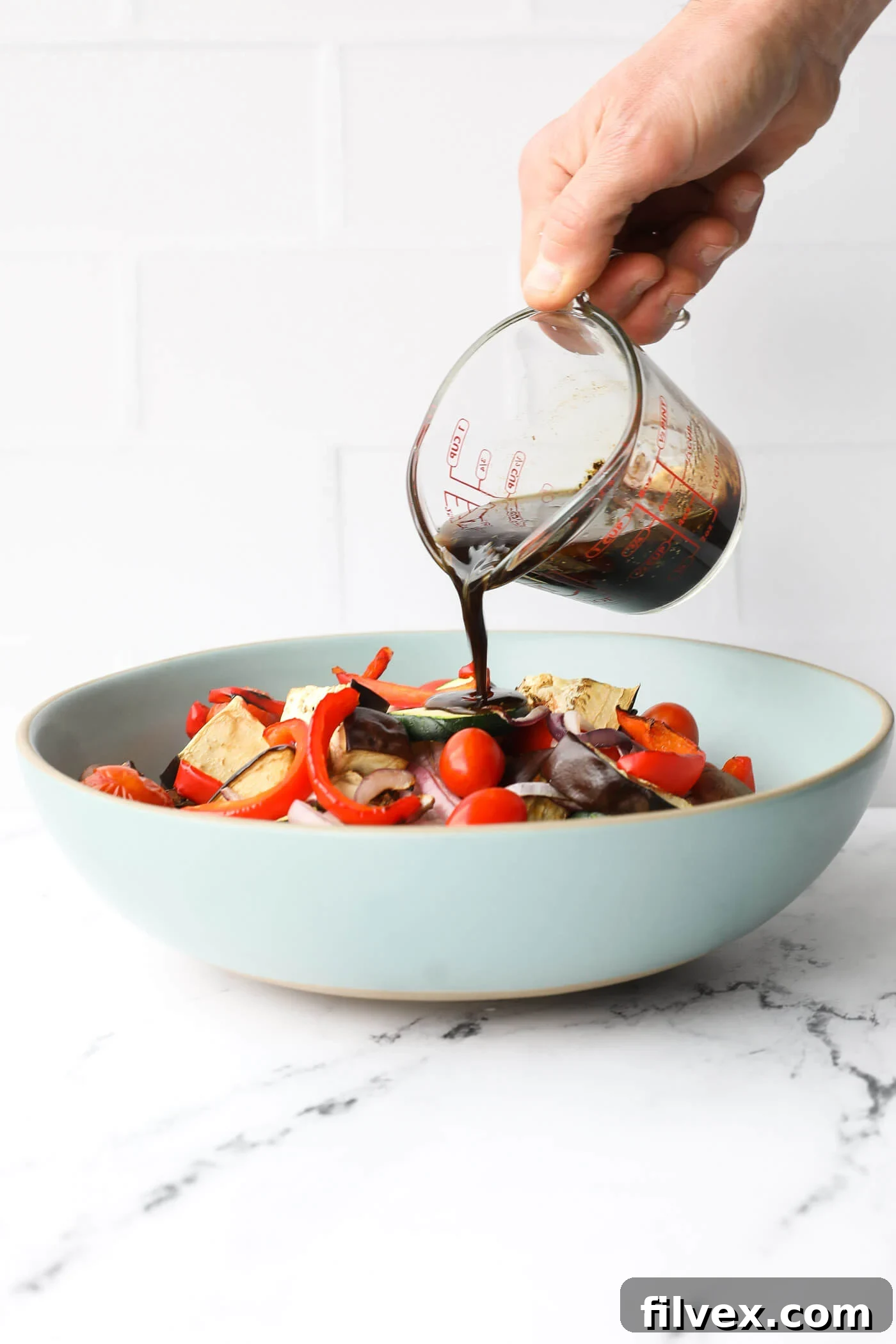 Fresh ingredients for the grilled vegetable marinade including olive oil, balsamic vinegar, garlic powder, dried basil, lemon, salt, and pepper.