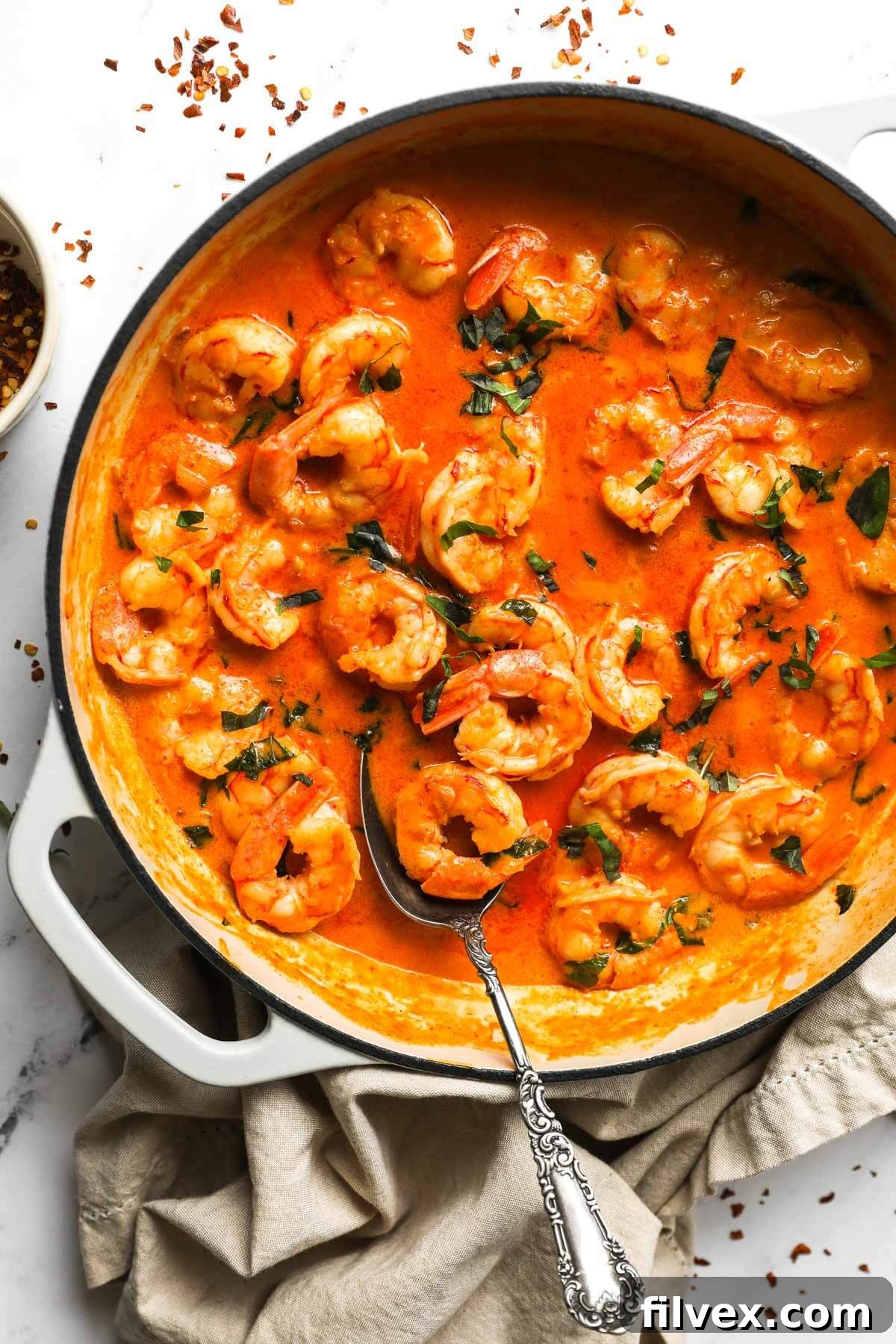 Ingredients for creamy coconut shrimp laid out, showing fresh basil, shrimp, and the creamy sauce components.