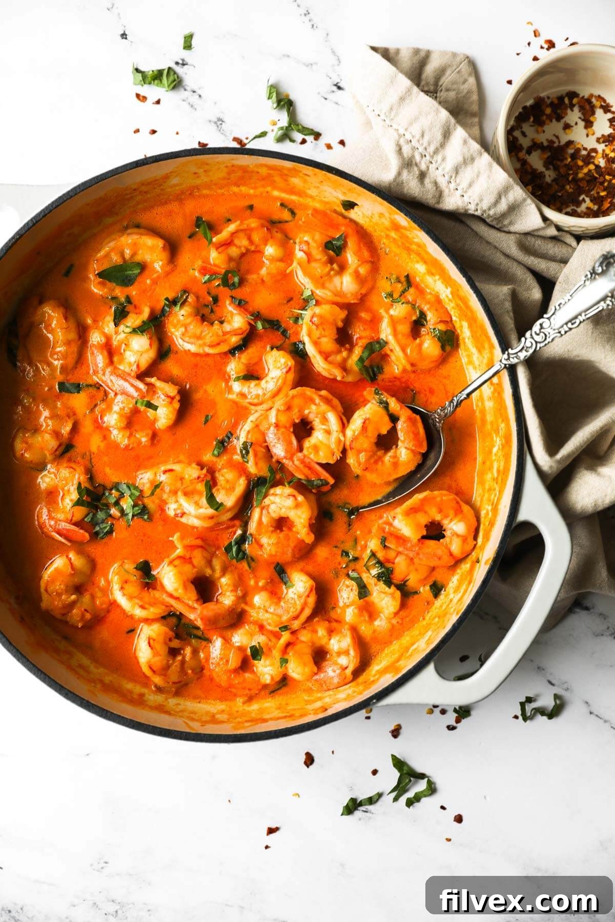 A dish of creamy coconut shrimp served over rice, garnished with fresh cilantro, ready for a meal.