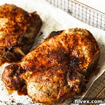 Close up angle image of bone in pork chops in air fryer basket