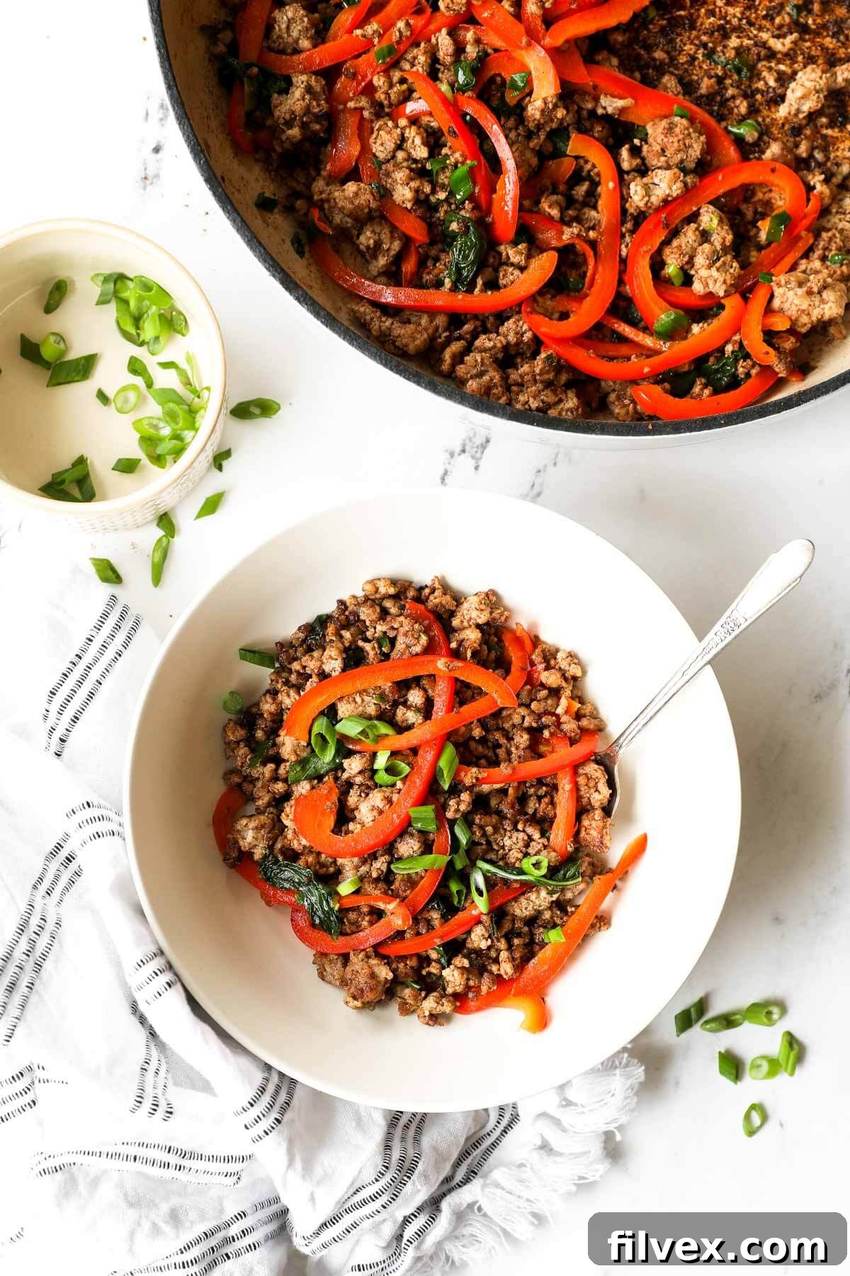 A vibrant bowl of Thai Basil Pork served with white rice and fresh greens, ready to be enjoyed.