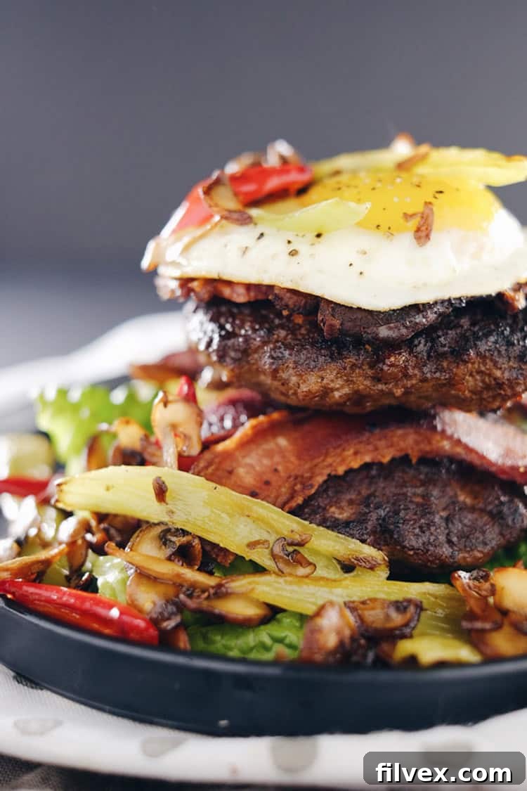 These chipotle bison burgers are an easy Paleo + Whole30 alternative to regular hamburgers. Topped with bacon, egg, peppers and mushrooms for amazing flavor! Paleo, Whole30, Gluten-Free + Dairy-Free | realsimplegood.com