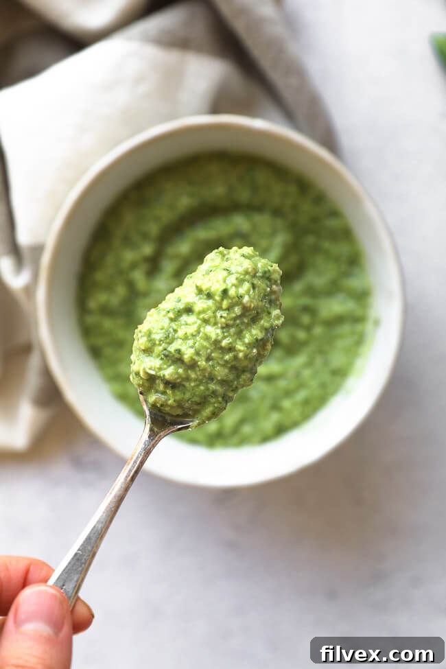 Overhead image of a spoonful of creamy dairy-free and nut-free pesto, showcasing its texture.