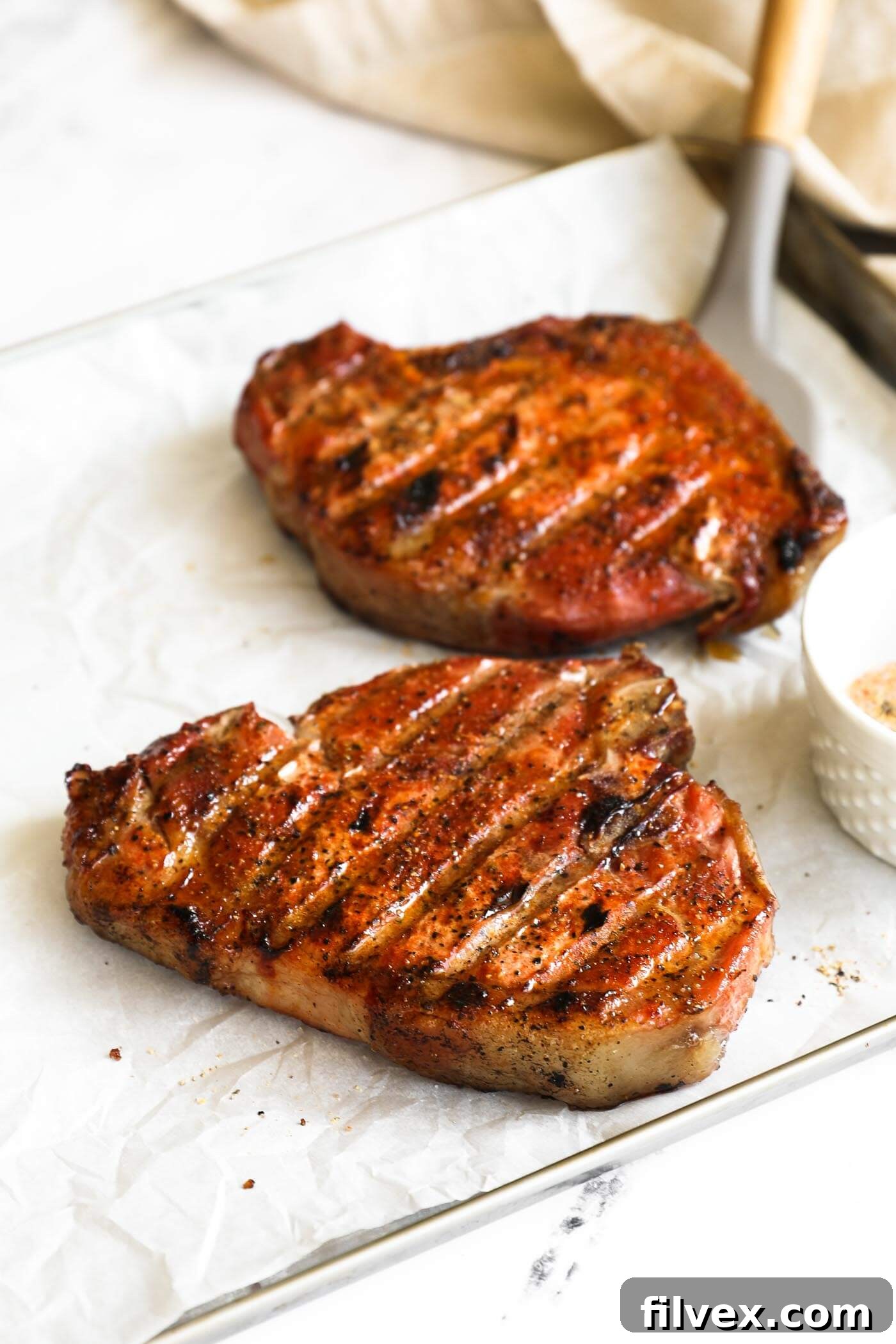 A close-up of a perfectly cooked, juicy Traeger smoked pork chop showing its inviting sear and tender interior.