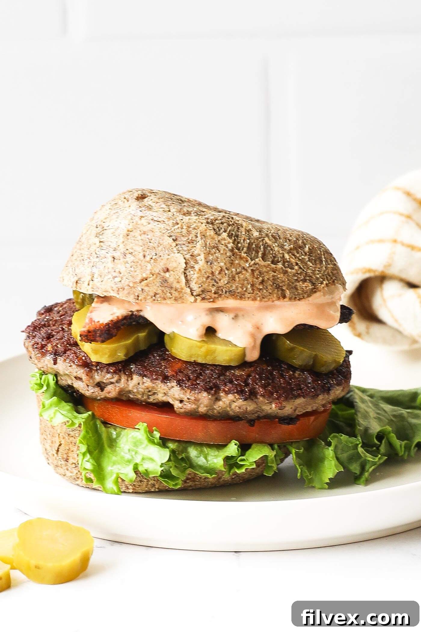 Close-up of a perfectly cooked stuffed keto burger on a bun with fresh toppings